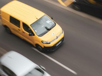 a yellow car and a white car on a road